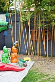 Bunte Deko im Garten mit Bambus und Dekobuchstaben vor der Mauer
