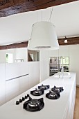 weiße Küchenarbeitsplatte mit Gasherd und Dunstabzug in restauriertem Landhaus