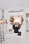 Festively decorated wood-burning cooker in white kitchen