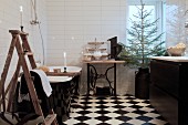 Schwarz-weisses Badezimmer mit Leiter, freistehender Badewanne, Nähmaschinentisch und Weihnachtsbaum