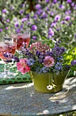 Romantisches Blumengesteck auf Vintage Gartentisch
