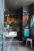 Schwarz gefliestes Bad mit Duschbereich