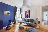 Retro living room with blue accent wall in renovated period apartment