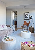 Gemütlicher Wohnbereich mit Polstercouch, Butterfly-Chair und Baumstamm-Hocker