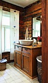 Rustic bathroom with countertop sink on top of old cabinet