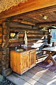 Dining table and outdoor kitchen on terrace of log cabin