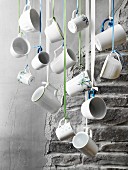 Various white cups hung from ribbons