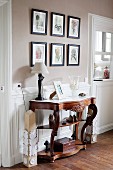 Carved antique console table against white wainscoting in traditional interior