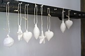 Christmas-tree baubles dipped in plaster and hung from hooks on wall