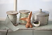 Easter bunny in front of reels of ribbon and vintage tin