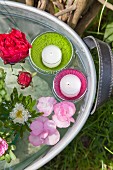 Flowers and floating candles in zinc tub of water