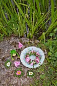 Blumenkranz aus Bartnelken, Hortensien und Gras im Teller
