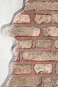 Wall with section of exposed brick and white render