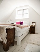 Bett unter dem Fenster im ländlich-romantischen Dachzimmer