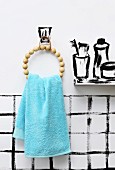 Towel holder hand-made from wooden beads in bathroom with painted walls