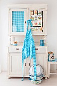 Blue and white checked apron hung from old kitchen dresser