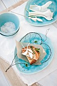 Tischdekoration mit filigranem Draht-Blattmotiv auf hellblauem Teller mit Snack