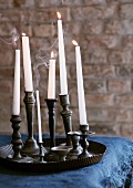Collection of pewter candlesticks in old baking tray