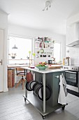 White board floor and island counter on castors in Scandinavian kitchen