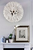 Feather headdress as wall decoration above the fireplace console