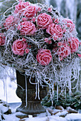 Vase with rose bouquet of silk in hoarfrost