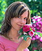 Young woman smelling pink (historical scent rose)