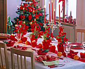 Tischdekoration mit Picea glauca 'Conica' in roten Töpfen und roten