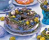 Easter wreath with grape hyacinths, feathers and eggs