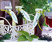Bottles with sambucus berries juice on metal tray