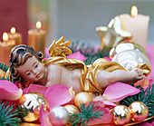 Angel in bed of roses, golden Christmas tree balls