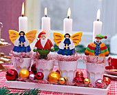 Adventskranz mit weißen Kerzen in Bechern, dekoriert mit Engeln, Nikolaus