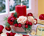 Gesteck mit Rosa (Rosen), Pseudotsuga (Douglasie), rote Weihnachtsbaumkugeln