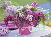 Syringa (lilac) bouquet in metal bucket on the table