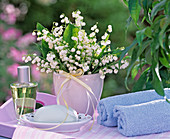 Convallaria bouquet, soap on dish, towels, perfume