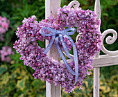 Light violet syringa (lilac) heart on white metal fence