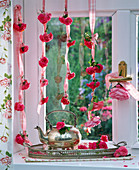 Rosa (Rosen) an Bänder geknotet am Fenster, Tablett mit Kanne, Rosen