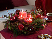 Advent wreath with red balls, branches and ivy