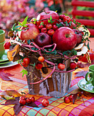 Gesteck aus Malus (Äpfeln, Zieräpfeln, getrockneten Apfelscheiben), Hedera