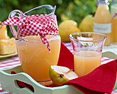 Freshly squeezed juice from Pyrus in pitcher with 'belly bandage' and in the glass