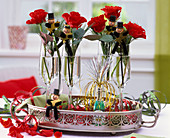 New Year's Eve decoration with roses, Pinus in champagne glasses on tray