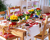 Carnival table decoration with primula, streamers, fritters