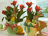 Tulipa 'Showwinner' with wooden rabbits and easter eggs in easter beakers