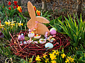 Easter nest in wreath of cornus (dogwood), wooden bunny, sugar eggs