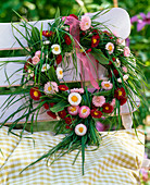 Bellis (daisies) and grasses wreath on the back of the chair