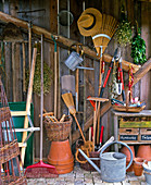 View into the tool shed with tools, wheelbarrow, pots