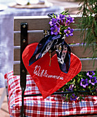Alpine flair with red wooden heart with scarf and Gentiana scabra