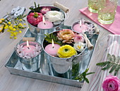 Small bucket with floating candles and flowers