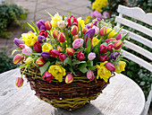 Basket with colorful tulipa and pittosporum arrangement