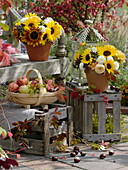 Autumn decoration with bouquets and apples on and in front of the bench
