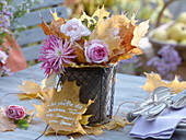 Wire basket with clay pot filled with leaves and flowers